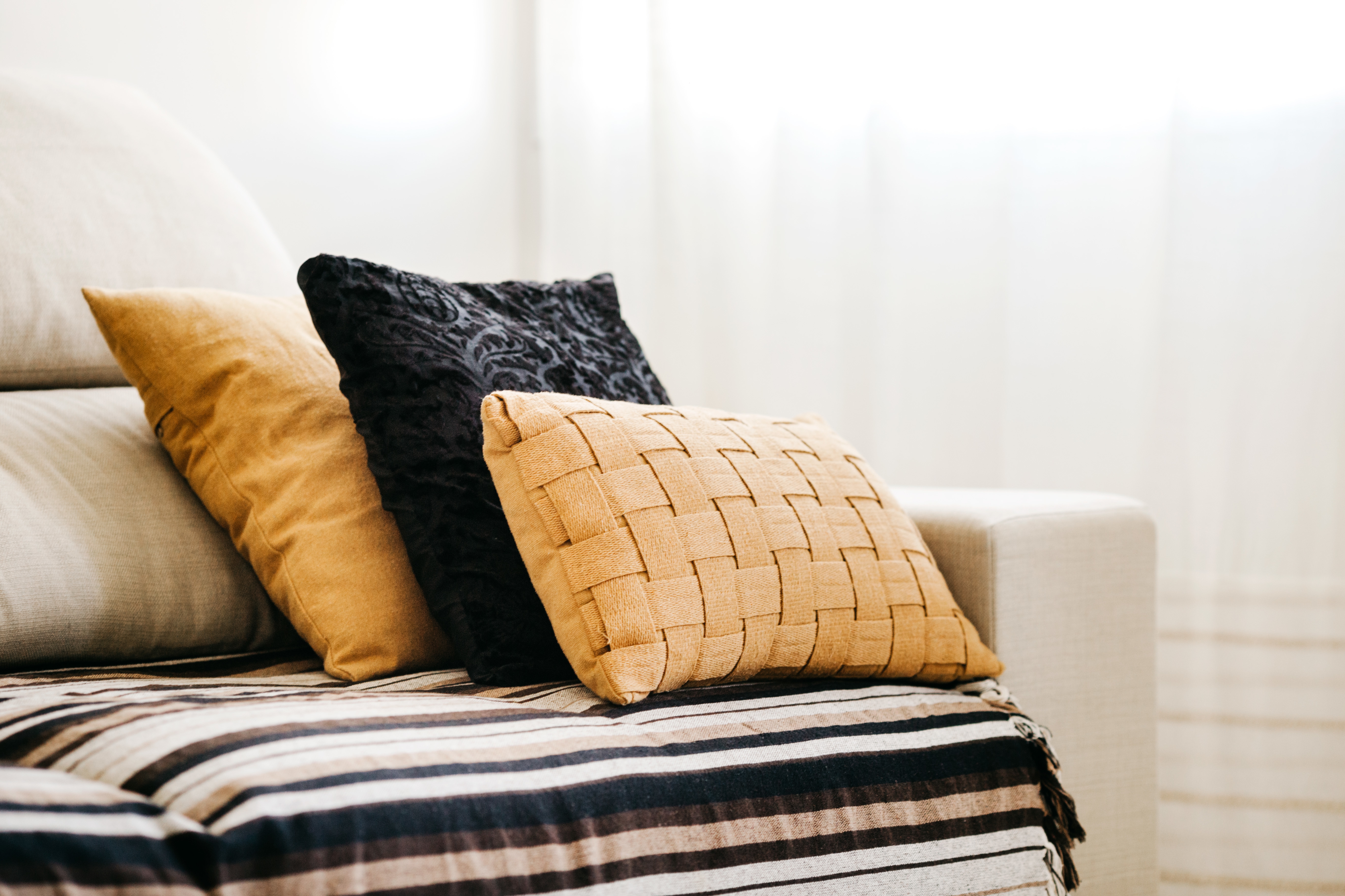 Closeup of black and yellow pillows on a white sofa